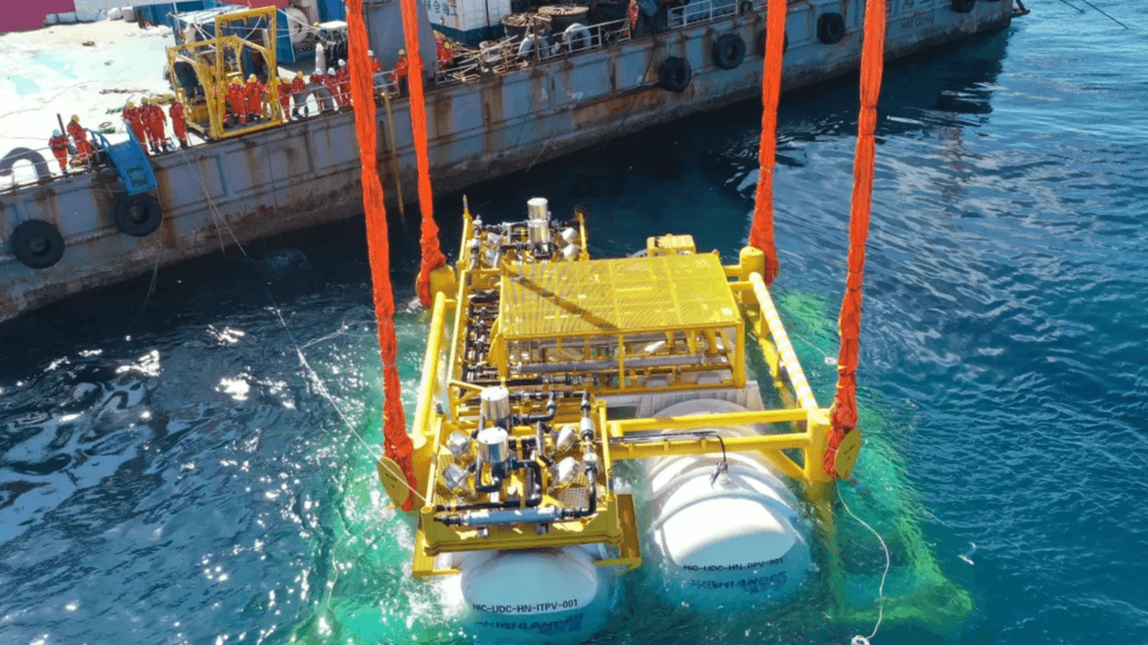 Massive cylindrical underwater data center submerged off Shanghai coast, with cables connecting to offshore wind…