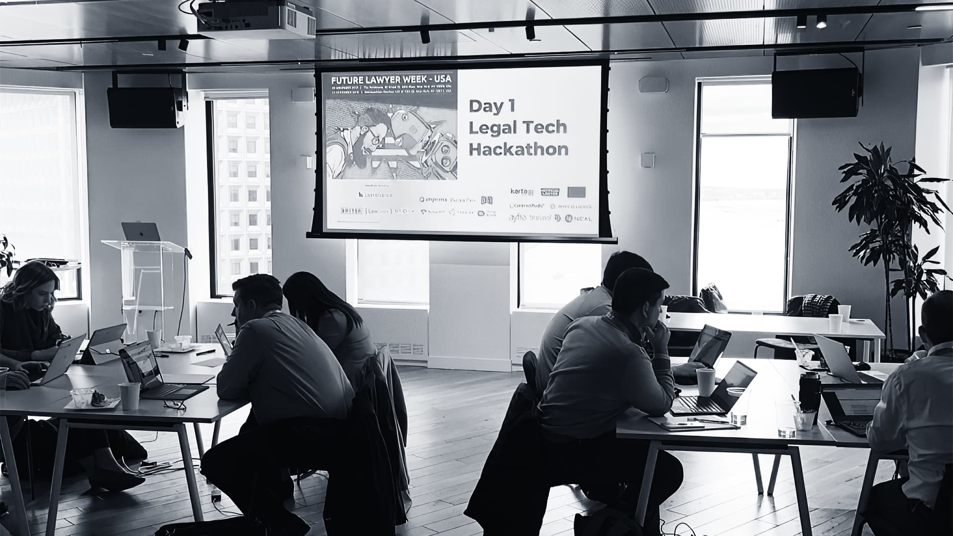 Developers collaborate on laptops at a bustling Union Square hackathon event, building marketing agent software for…