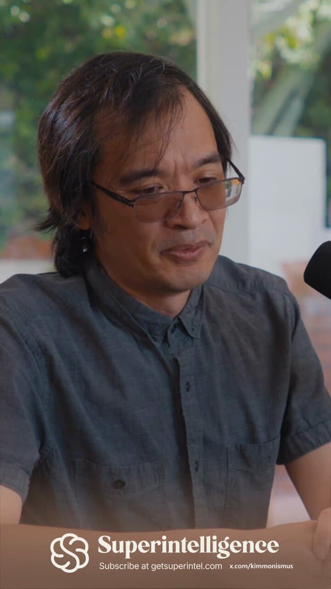 Mathematician Terence Tao speaking at a podium, gesturing with one hand, with a presentation slide visible behind him