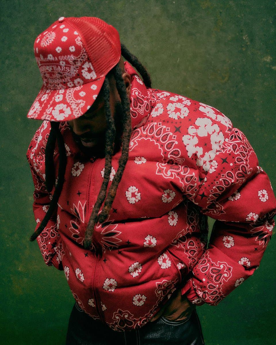 A model wearing a leopard-print coat and denim ensemble, posed against a studio backdrop with archival fashion…