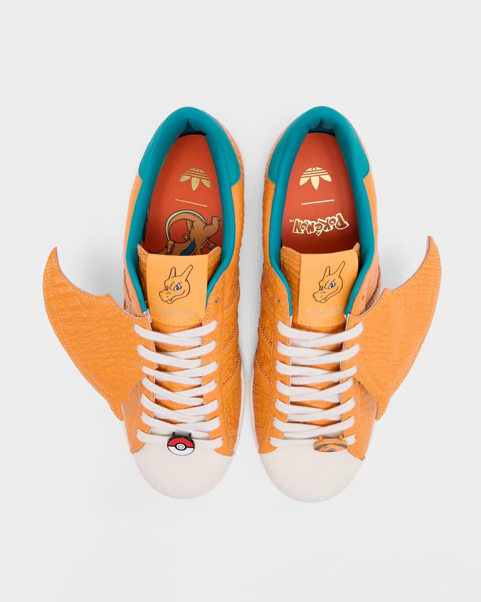 Close-up of colorful Pokémon-themed adidas sneakers displayed on a clean studio surface, with Pikachu motifs and…