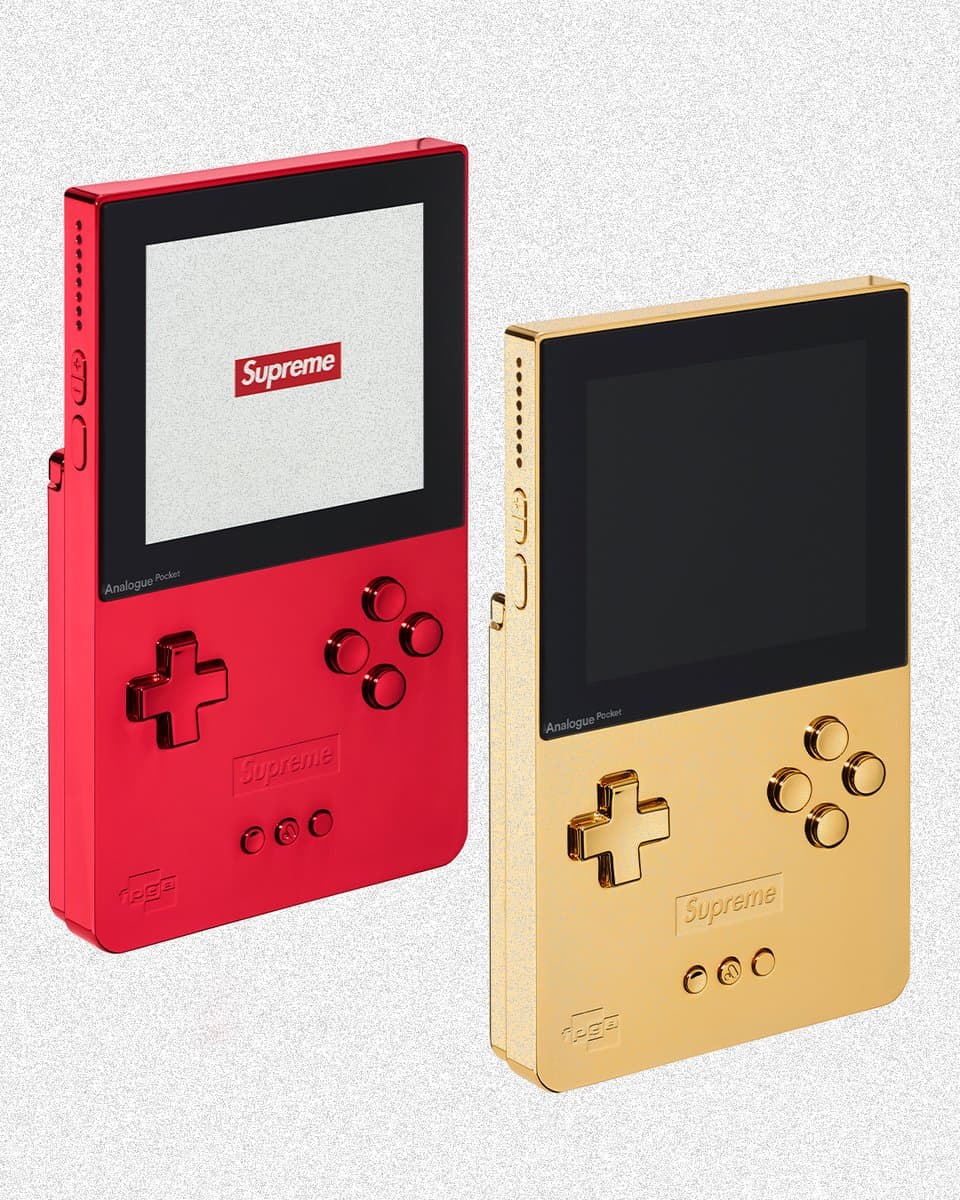 Gold and glossy red handheld gaming consoles with classic Game Boy design, displayed against a dark backdrop with…
