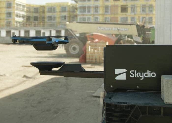 Skydio drone perched on a robotic arm mounted atop a vehicle, poised for automated launch or catch