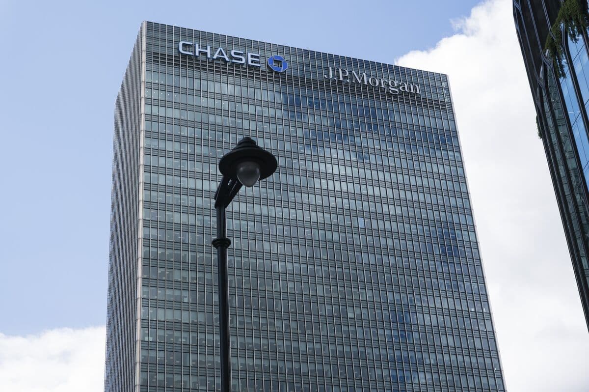 A JPMorgan Chase bank branch exterior with a sleek glass facade and the company logo above the entrance, set in a…