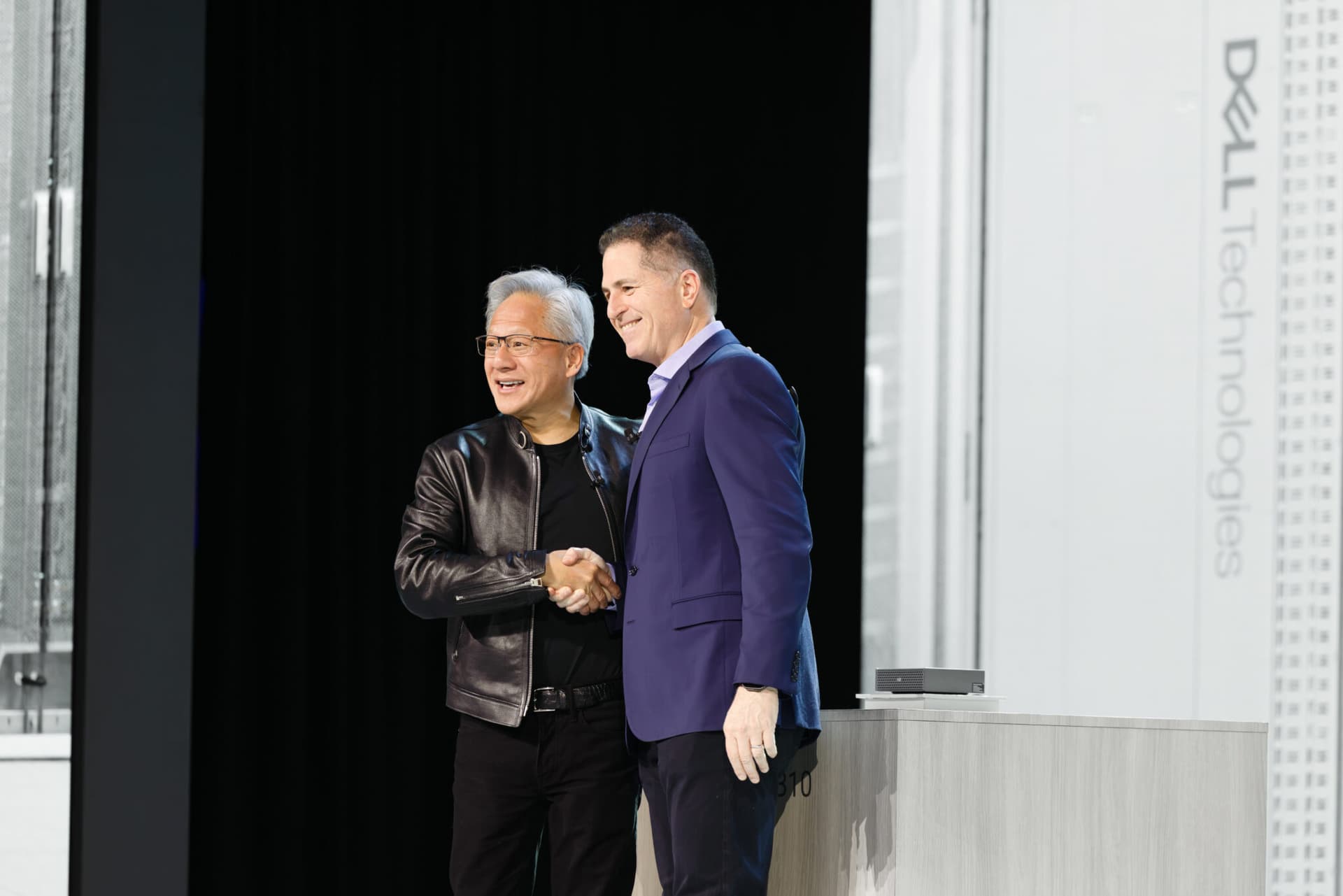 NVIDIA CEO Jensen Huang onstage at Dell Technologies World, gesturing toward a large screen displaying the Vera…