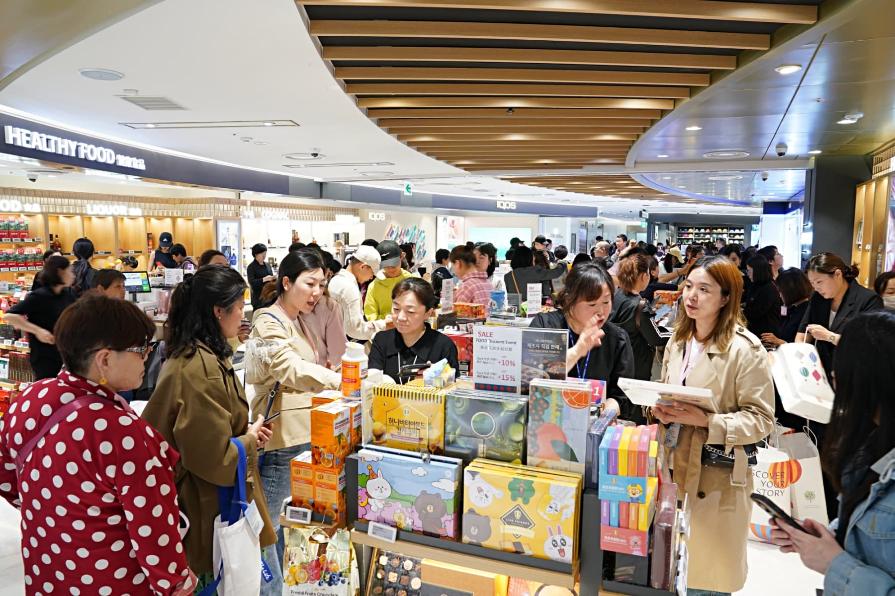 Shoppers browse a bright Lotte Department Store aisle while a digital kiosk displays AI-powered travel recommendations