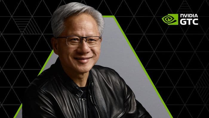 Jensen Huang onstage at GTC 2026, gesturing toward a lineup of humanoid and industrial robots under bright lights…