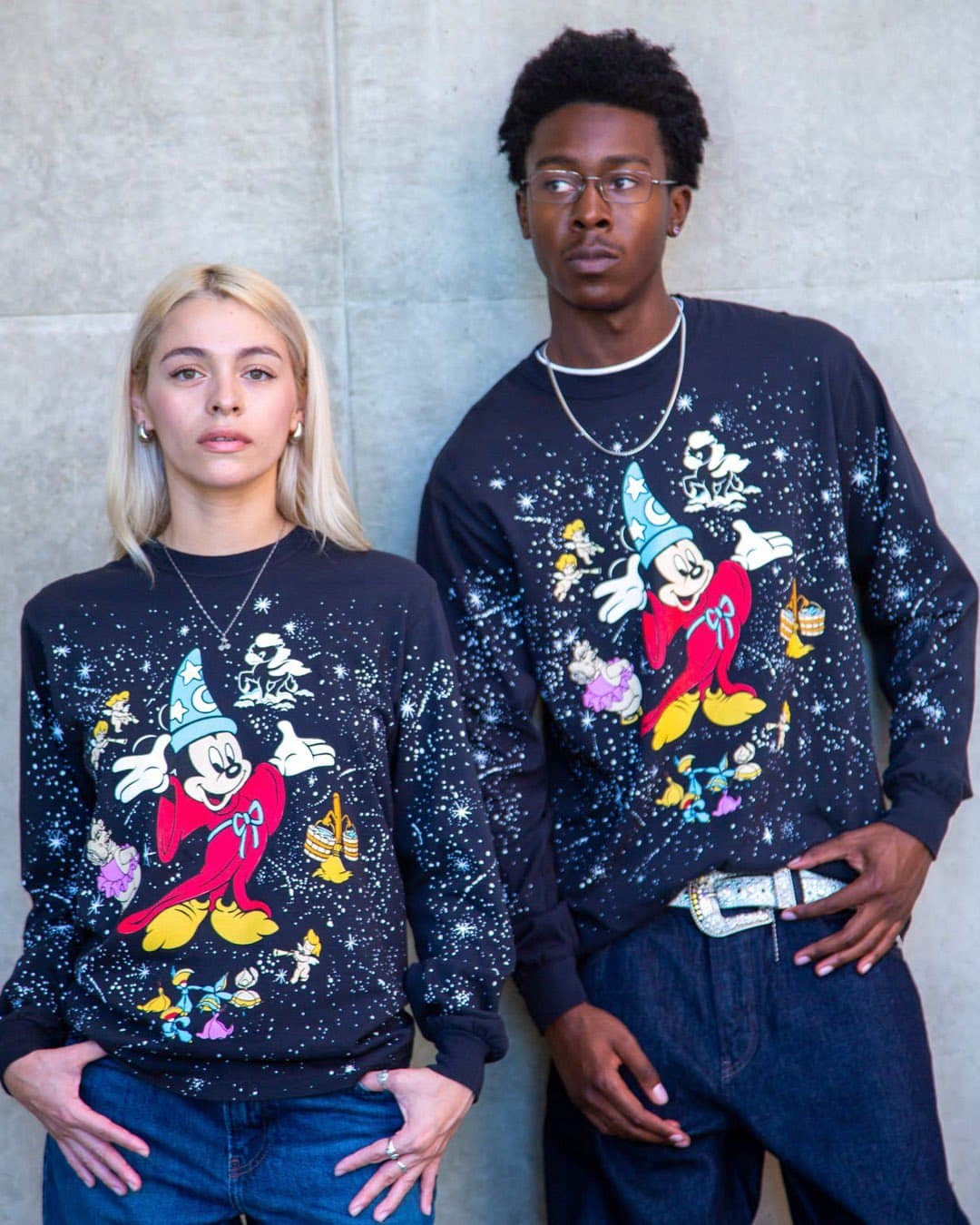 Streetwear designer Bobby Hundreds holds up a vintage Fantasia Mickey Mouse t-shirt with bold graphics, set against…